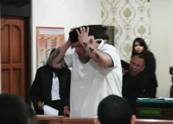Daniel Domalski wears a peci (traditional Indonesian cap) after the verdict hearing at the Denpasar District Court on Tuesday (16/12).