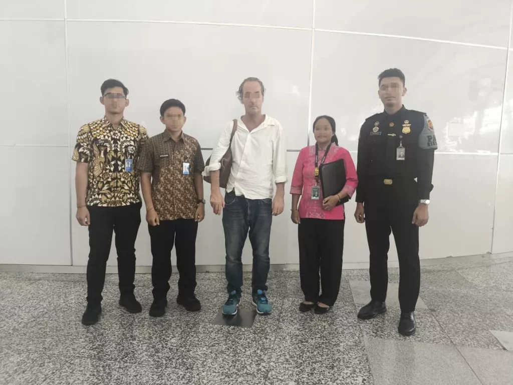 Photo of Andrew Joseph McLean with Immigration officers when he was about to be deported at Bali Airport.