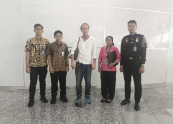 Photo of Andrew Joseph McLean with Immigration officers when he was about to be deported at Bali Airport.