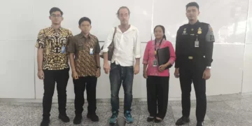 Photo of Andrew Joseph McLean with Immigration officers when he was about to be deported at Bali Airport.