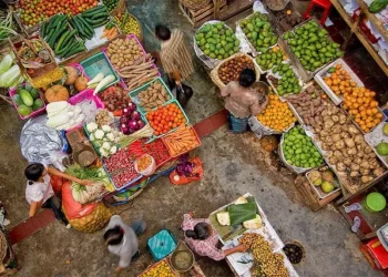 Buying and selling activities in Bali's traditional markets, with traders and buyers interacting among food commodities, reflect the dynamics of people's daily consumption.