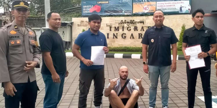 Belarusian citizen Pisarenka Pavel raised his middle finger when handed over to Singaraja Immigration on Tuesday (January 27, 2026). (Photo: Buleleng Police)