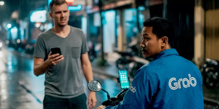 Illustration photo of a drunk tourist in Bali ordering a motorbike taxi service in the rain on a road in Bali (Photo created by AI)