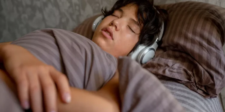 Illustration of a person sleeping with headphones. The fire in Denpasar, Bali, exposed the dangers of sleeping with headphones. (Hey Bali/ Freepik)