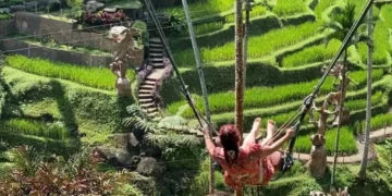 One of the tourists is trying out the swing activity in Ubud, Bali.
