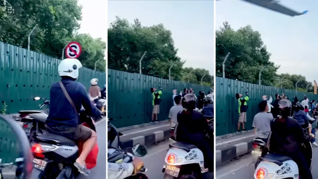 Screenshot of a video of Balinese residents stopping at the side of the road just to record a plane taking off (Hey Bali)