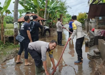 Officers carry out emergency response at a residential area in Seririt District, Buleleng, affected by the overflowing Banyu Raras River, Sunday (February 1, 2026). (Photo: Buleleng Police doc.)
