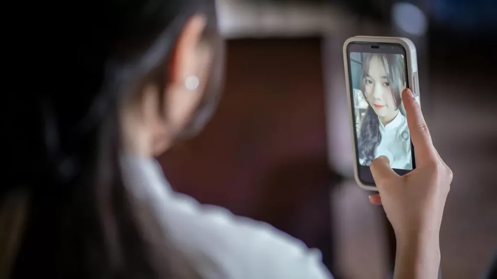 Illustration photo of a woman taking a selfie with a cellphone made by Apple