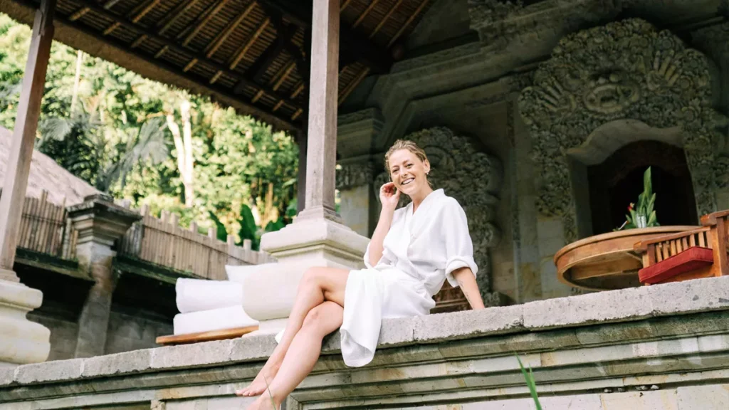 The Real Cost of Buying Property in Bali: 7 Hidden Expenses Every Investor Must Know 3 Illustration photo of a Caucasian woman relaxing on the front porch of her newly purchased house in Bali (Pexels)