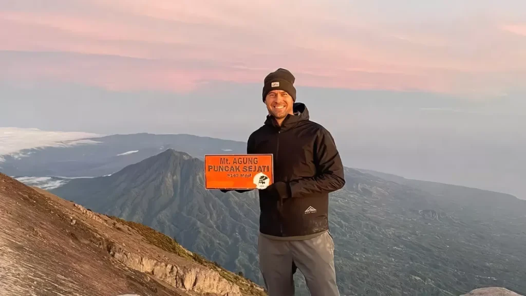 Photo of a European tourist taking a photo at the peak of Mount Agung, Bali (IST)