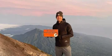 Photo of a European tourist taking a photo at the peak of Mount Agung, Bali (IST)