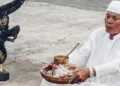 Photo of a Hindu priest in Bali praying in front of a temple (Pexels)