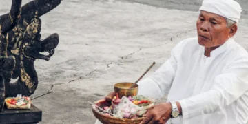 Photo of a Hindu priest in Bali praying in front of a temple (Pexels)