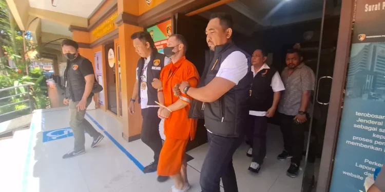 Photo: Steven Lyons being escorted to a detention van at Bali Police Headquarters, Tuesday (March 31, 2026).