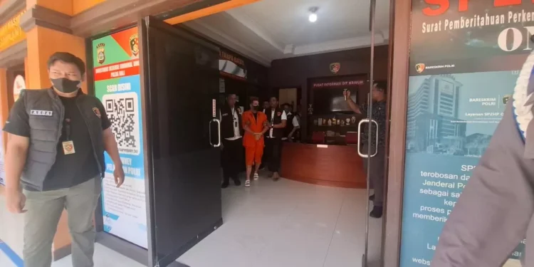 How Bali Immigration Detected and Detained a British Interpol Fugitive at Entry 37 Photo: Steven Lyons being escorted to a detention van at Bali Police Headquarters, Tuesday (March 31, 2026).(Hey Bali)