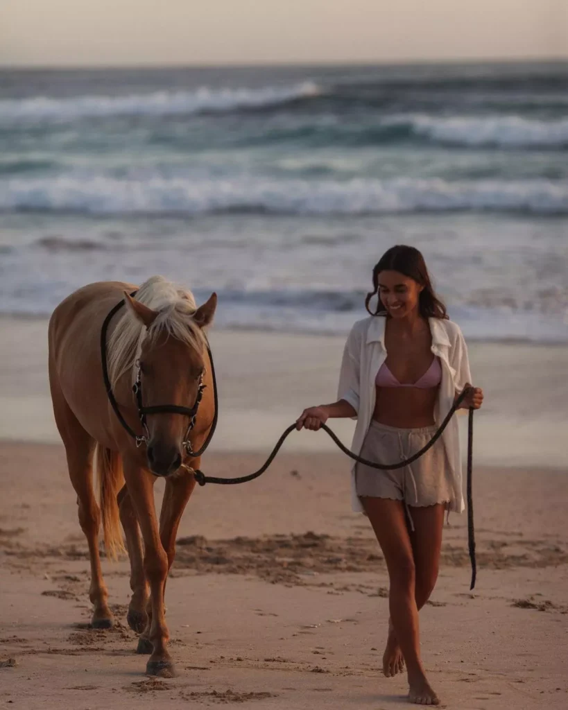 Sumba Tourism: Why Travelers Are Trading Scooters for Horses and Traditional Dress 41
A female tourist is posing on a beach in Sumba while riding a horse.