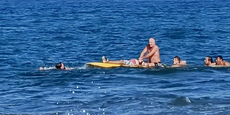 Photo: Murtiningsih receiving first aid from Gianyar Balawista (lifeguard) personnel and several foreign tourists at the water's edge, Wednesday (June 24, 2026). (Courtesy of BPBD Gianyar)