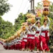 Balinese Hindu women carry colorful ceremonial offerings during a Galungan procession in a traditional village in Bali, Indonesia, celebrating the victory of good over evil.