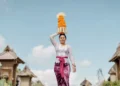A river of devotion flows through a Balinese village as women carry elaborate gebogan offerings during Galungan, one of Bali's most sacred celebrations honoring the triumph of good over evil.