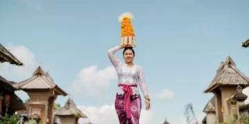 A river of devotion flows through a Balinese village as women carry elaborate gebogan offerings during Galungan, one of Bali's most sacred celebrations honoring the triumph of good over evil.