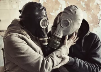 Two people wearing gas masks embrace each other, symbolizing emotional manipulation, toxic relationships, and hidden psychological control.