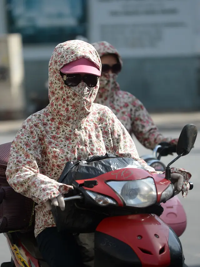 Riding a Scooter in Bali? Here's What Sun, Heat, and Pollution Are Actually Doing to Your Skin 41 A female motorcyclist wears protective clothing and sunglasses while riding through downtown Hanoi on Wednesday (June 15). Vietnam is facing a heatwave with temperatures reaching up to 40 degrees Celsius. (Hoang DINH NAM/AFP)
