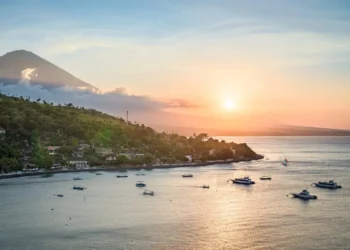 Sunset Point Amed, Bali: 5 Reasons This East Bali Clifftop Deserves a Spot on Your Itinerary 41 A view of the north coast of Bali at sunset—featuring the peak of Mount Agung, forested slopes, and the Java Sea—seen from a hilltop near Amed, Bali, Indonesia. (depositphotos.com/emcamposphoto)