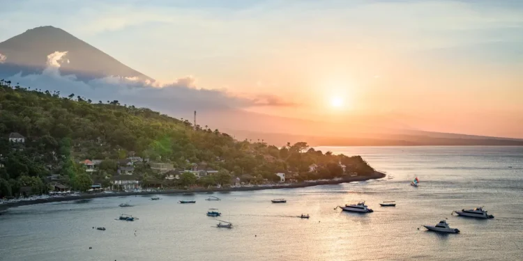 Sunset Point Amed, Bali: 5 Reasons This East Bali Clifftop Deserves a Spot on Your Itinerary 37 A view of the north coast of Bali at sunset—featuring the peak of Mount Agung, forested slopes, and the Java Sea—seen from a hilltop near Amed, Bali, Indonesia. (depositphotos.com/emcamposphoto)