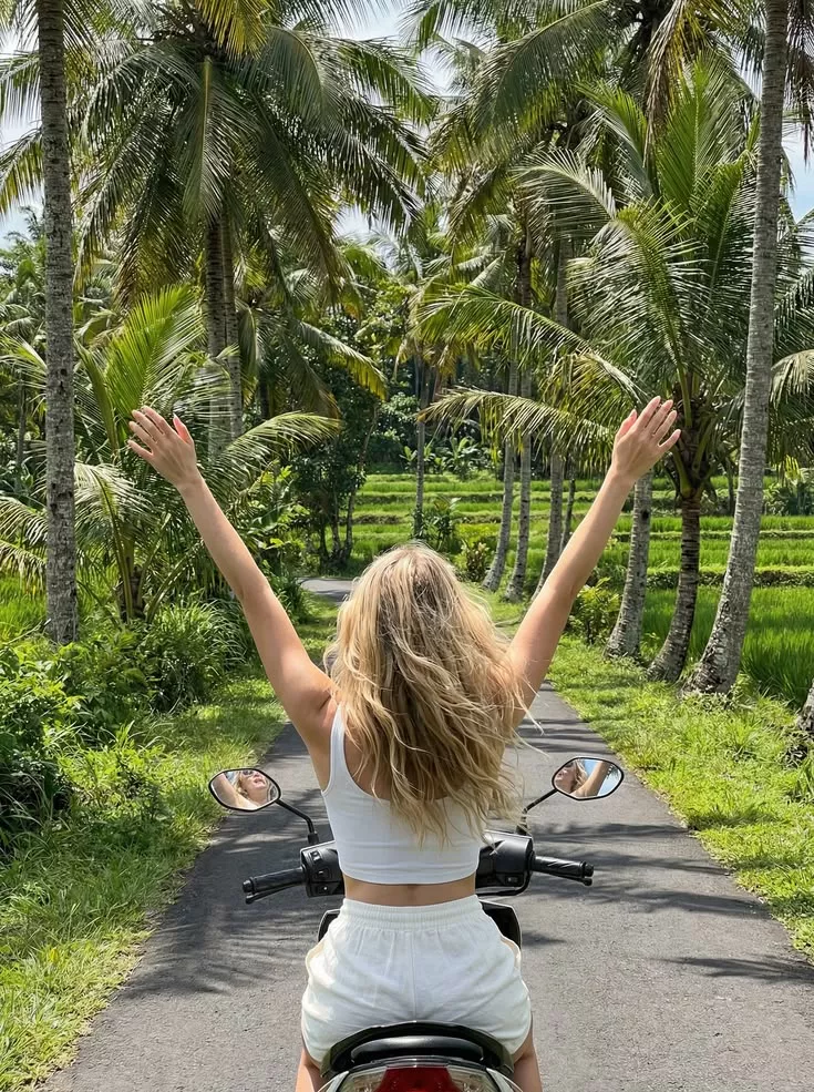 Riding a Scooter in Bali? Here's What Sun, Heat, and Pollution Are Actually Doing to Your Skin 38 Tourist riding a scooter in Bali through rice fields under the tropical sun, highlighting the importance of skincare and sun protection for daily scooter riders.