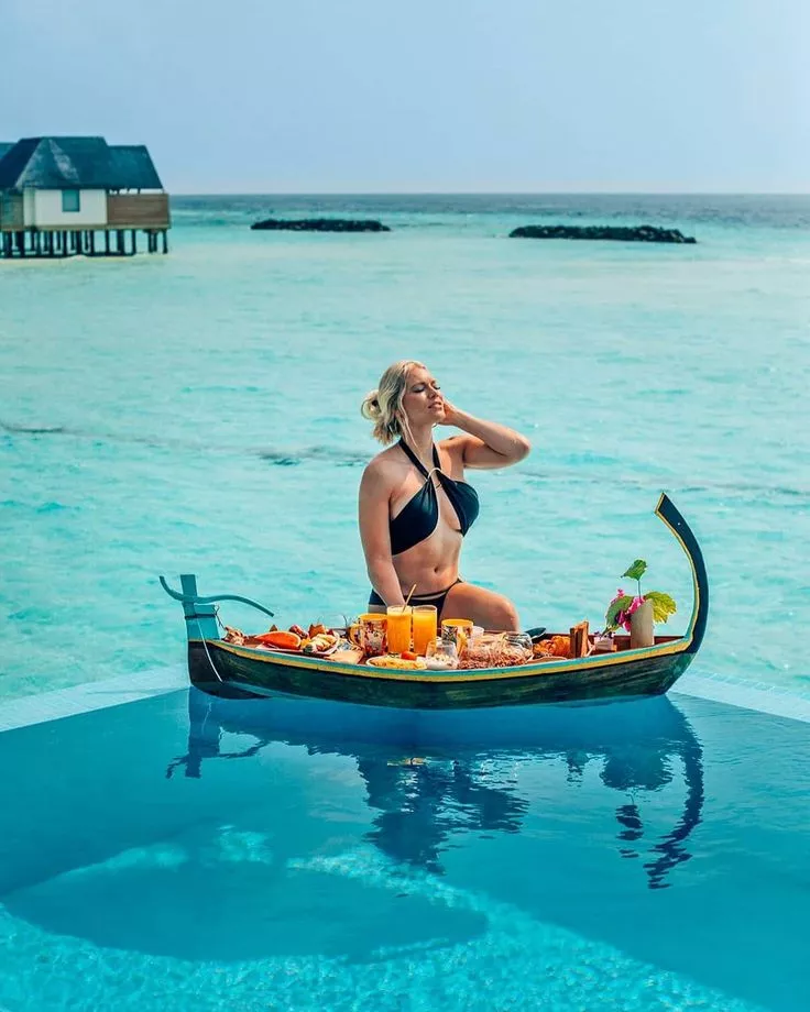 Can You Swim After Eating? What the Science Actually Says 39 A photo of a female tourist having breakfast in the pool, with a view of the blue sea in the background.