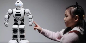 An illustrative photo of a young girl interested in learning about technology and AI through robotics.