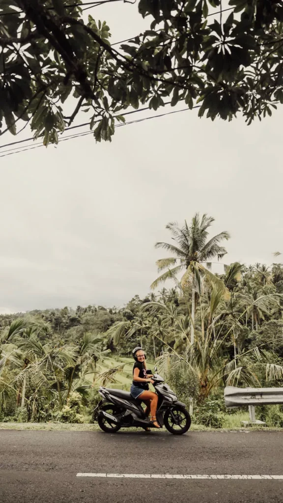 Bali Rules for Tourists: What You Can and Can't Do Before You Visit. 41 Tourist riding a scooter in Bali with a helmet while following Bali scooter rules and driving regulations for foreign visitors.