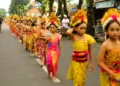 Young Balinese girls take part in a traditional cultural procession, reflecting the next generation preserving Bali's cultural heritage and identity.