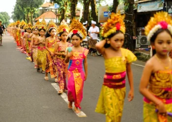 Young Balinese girls take part in a traditional cultural procession, reflecting the next generation preserving Bali's cultural heritage and identity.