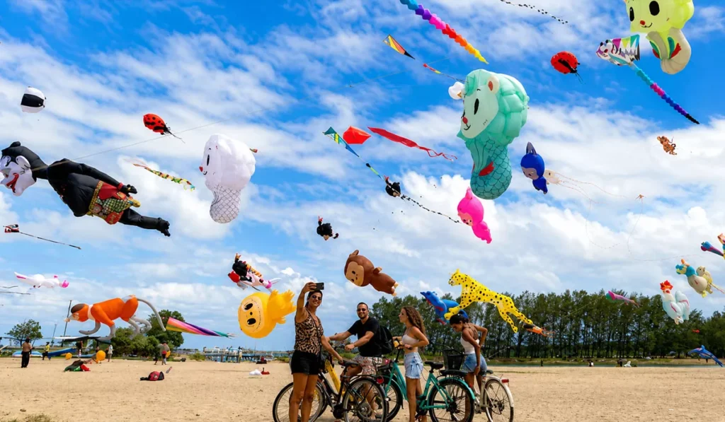 Thousands of Kites, Some Over 25 Meters Long, Take Over Sanur's Skies for Bali's Rare Angon Festival 2 Visitors watch giant international kites during the Rare Angon Festival at Mertasari Beach in Sanur, Bali.