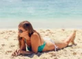 Why Bali Feels Hotter Than the Thermometer Says - Photo of a female tourist sunbathing on a Balinese beach. The weather looks hot and sunny.
