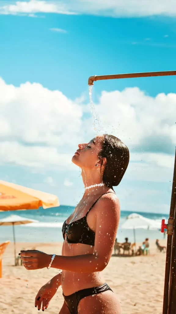 Why Bali Feels Hotter Than the Thermometer Says 40
A photo of a woman rinsing off with fresh water at a beach in Bali.