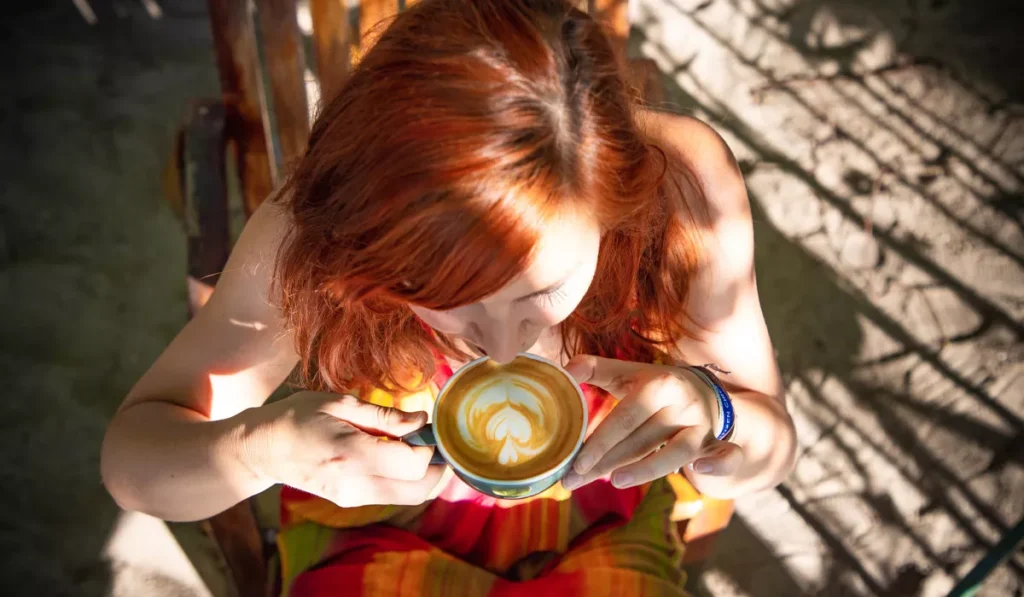 What Your Coffee Order at a Canggu Cafe Might Say About You, According to Psychology 39 Woman drinking a latte at a Bali café, illustrating coffee personality research on latte drinkers and social behavior.