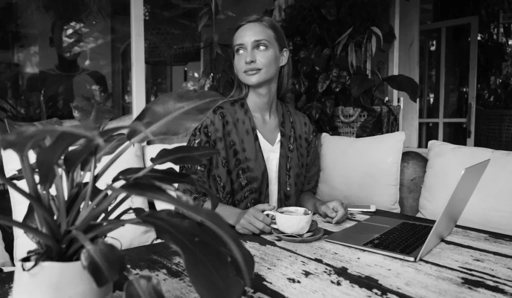 Digital nomad working from a Bali café with coffee, reflecting the connection between coffee culture, productivity, and personality.