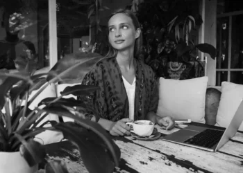 Digital nomad working from a Bali café with coffee, reflecting the connection between coffee culture, productivity, and personality.