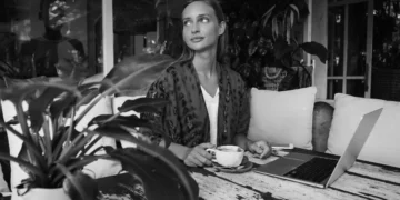 Digital nomad working from a Bali café with coffee, reflecting the connection between coffee culture, productivity, and personality.