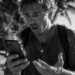 Tourist holding an overheating smartphone while traveling in Bali, illustrating why phones overheat when charging in Bali's tropical heat.