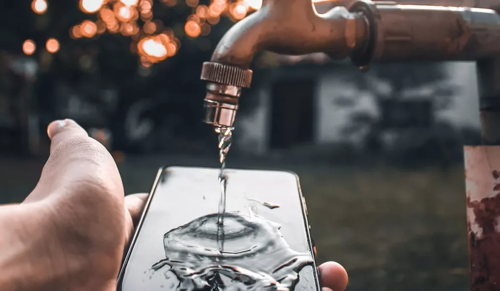 Why Does Your Phone Overheat When Charging, and Why Does It Get Even Worse in Bali? 40 Cooling an overheating smartphone with water nearby after prolonged charging in a hot environment.