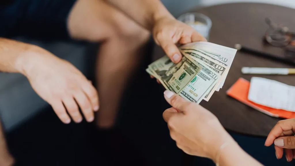 Illustrative photo of someone lending money to another party.