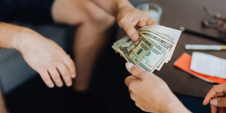 Illustrative photo of someone lending money to another party.