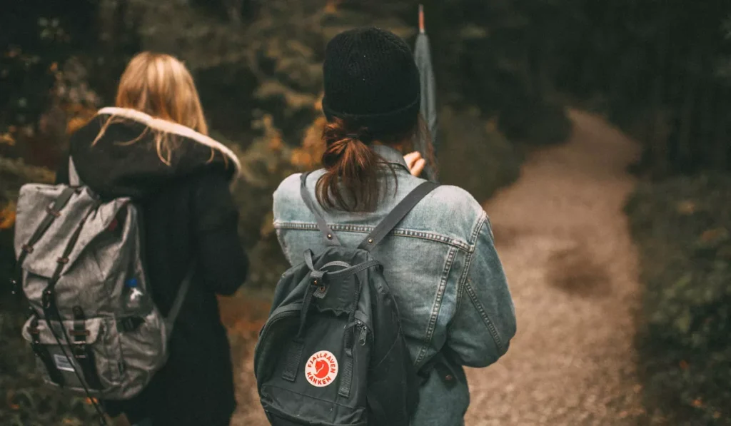 Ruck walking with weighted backpacks on a forest trail, illustrating the growing fitness trend that could become popular in Bali.