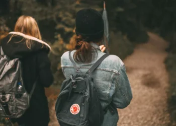 Ruck walking with weighted backpacks on a forest trail, illustrating the growing fitness trend that could become popular in Bali.
