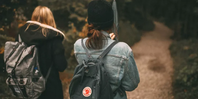 Ruck walking with weighted backpacks on a forest trail, illustrating the growing fitness trend that could become popular in Bali.