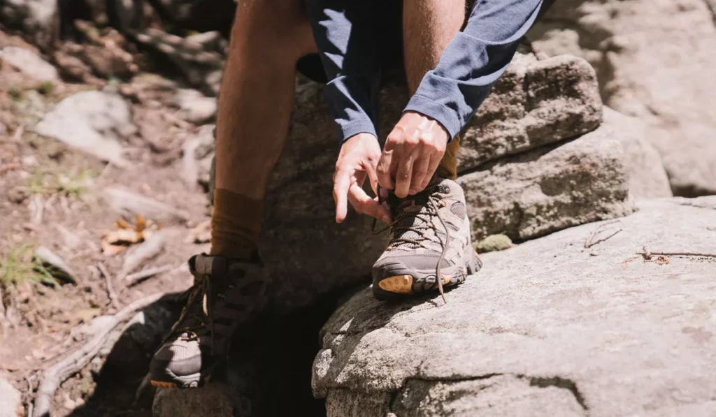 What Shoes Should You Wear in Bali? Sandals, Sneakers or Hiking Boots? 41 Hiking shoes for Bali being laced before a trek, the best footwear for Mount Batur, waterfalls, and rugged hiking trails.