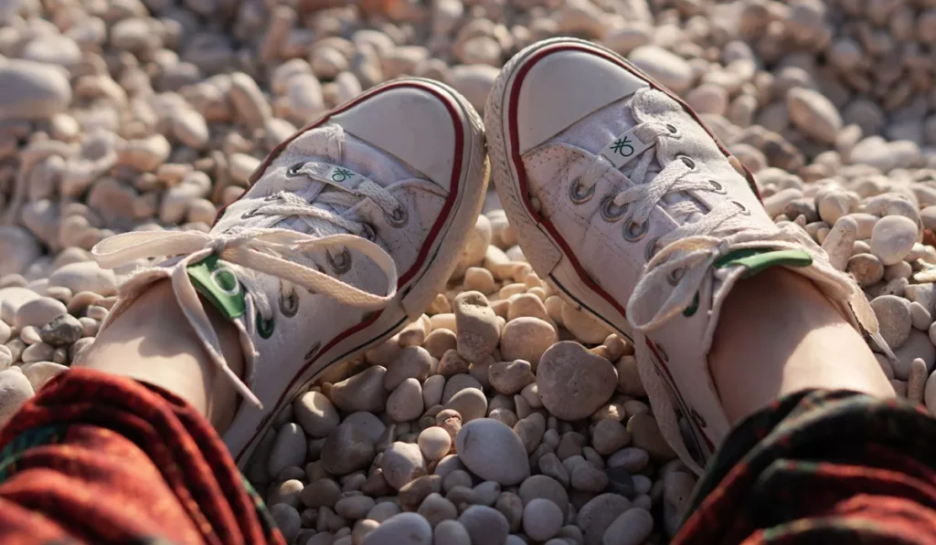 What Shoes Should You Wear in Bali? Sandals, Sneakers or Hiking Boots? 38 White sneakers for Bali travel on a rocky beach, showing why comfortable walking shoes are ideal for exploring the island.